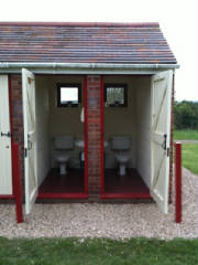 The toilet block, a small brick building with two cubicles